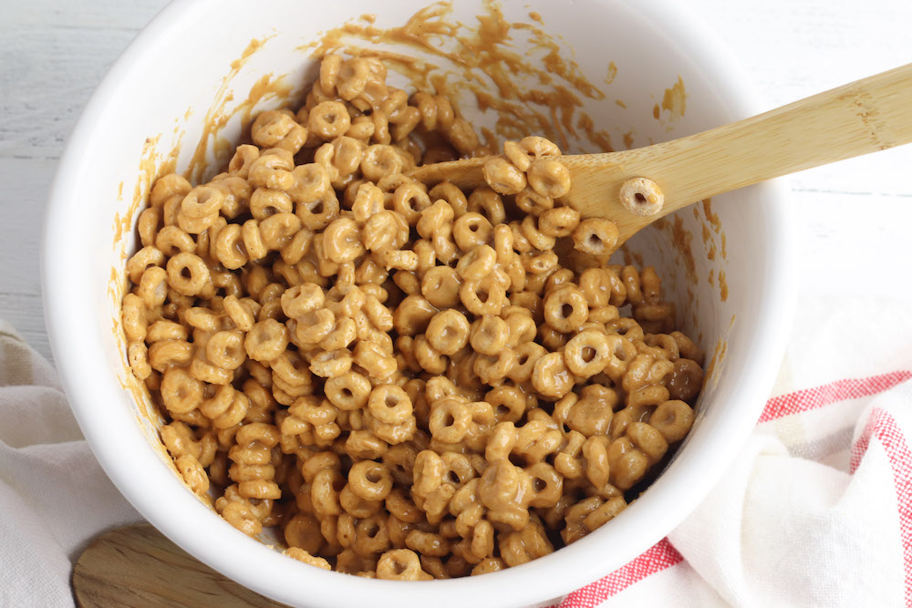 mixing cheerios with honey and peanut butter