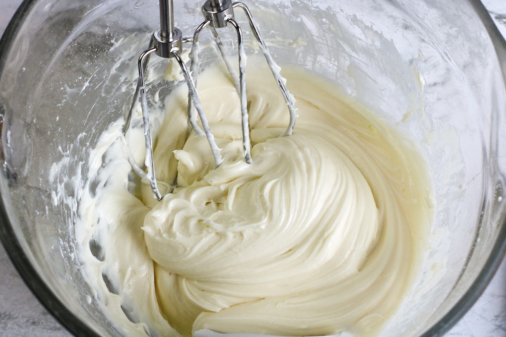 Mixing cream cheese, vanilla, and powdered sugar