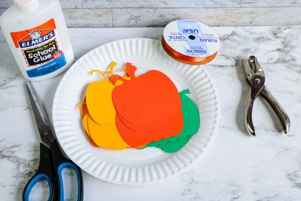 using a pumpkin template, cut out the pumpkin pieces to attach to the paper plate wreath. free pumpkin template, paper plate wreath, paper plate pumpkin