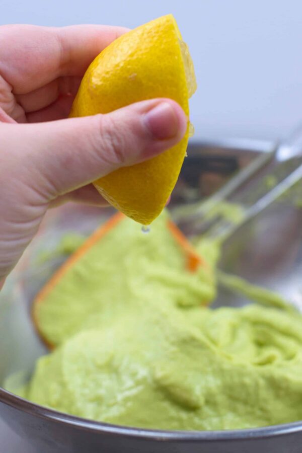 Adding lemon juice to homemade guacamole