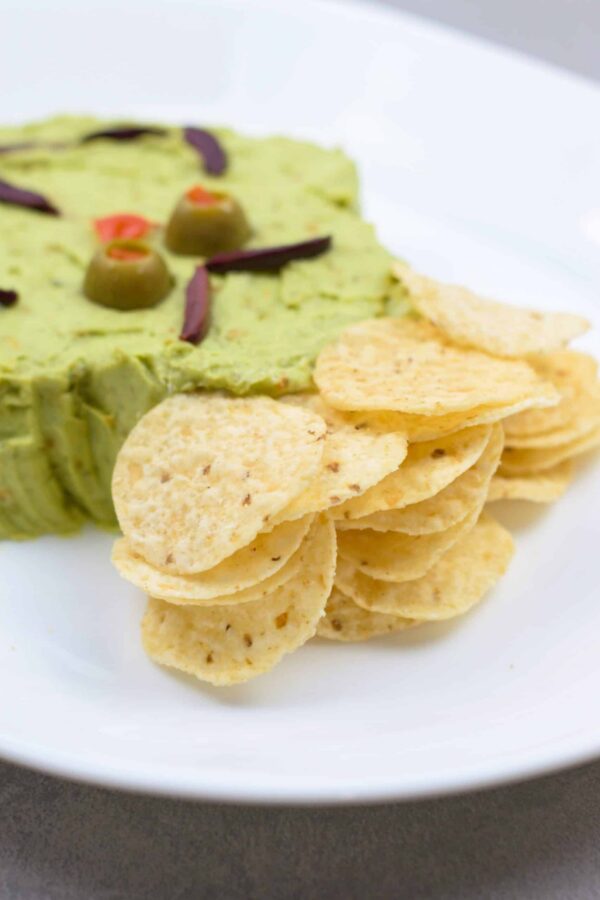 Tortilla chips arranged beside the Grinch guacamole.