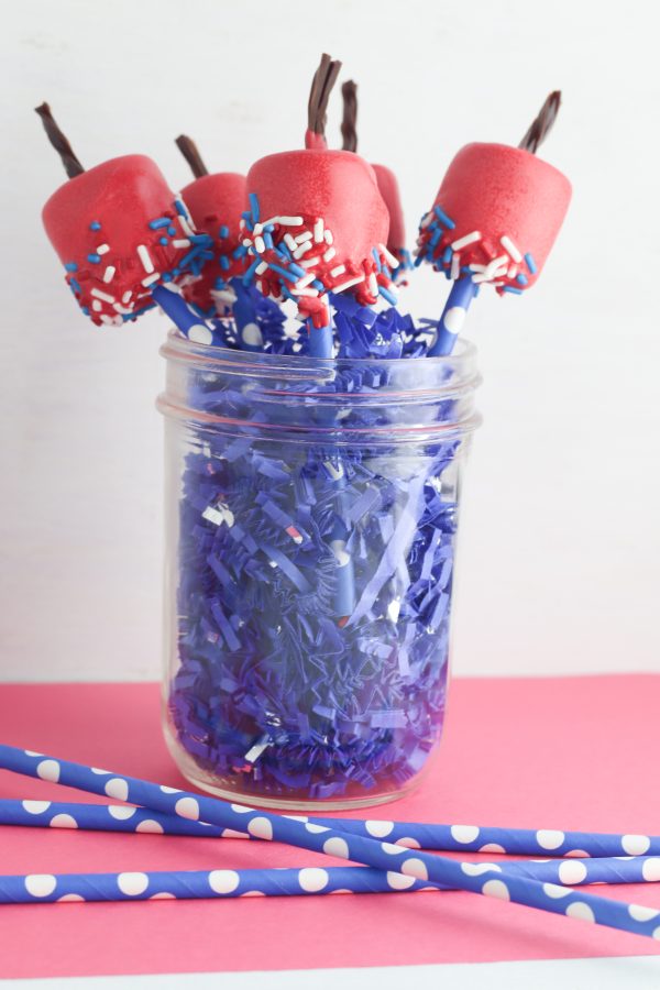 red marshmallow chocolate dipped pops with licorice sticks as firecrackers