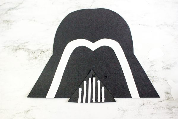 Place the mouth bars over the triangle cut from the black construction paper. 