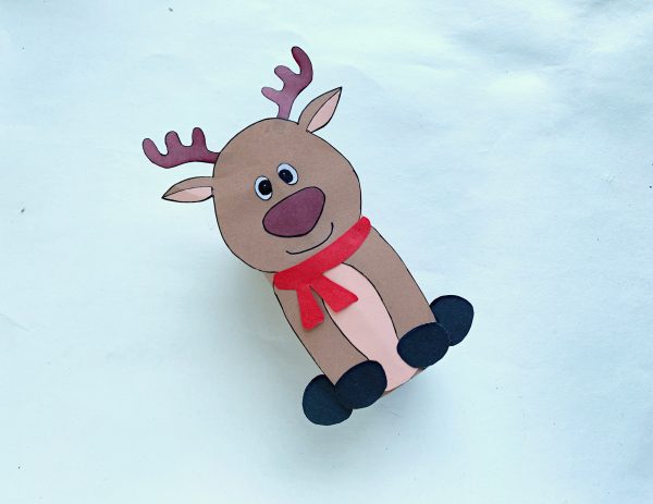 Crafted reindeer with red scarf on a snowy background