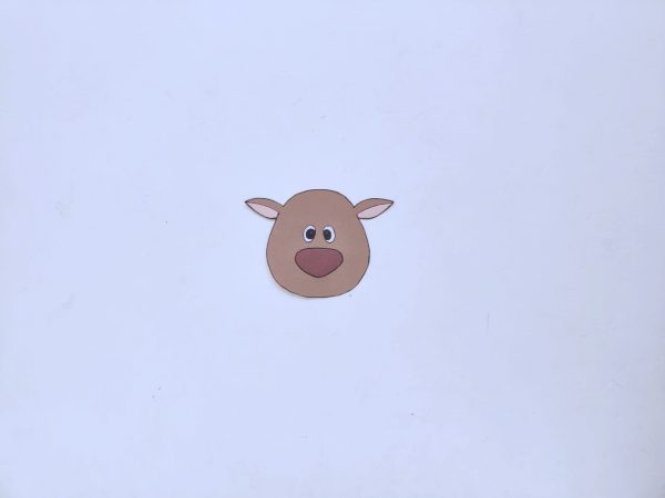 Cut-out of a brown reindeer's head with large red nose, round black eyes, and pointy ears