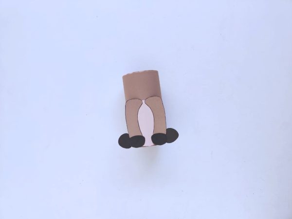 Brown paper roll with cut-out pink oval, cut-out brown legs, and black feet cut-outs
