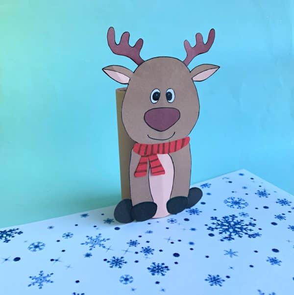 Reindeer cutout with scarf on snowflake-patterned surface, blue background