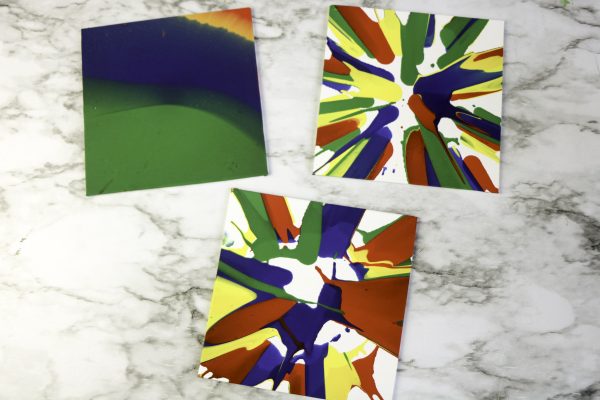 Three colorful cards on a marble surface: two with paint splashes and one green-blue gradient