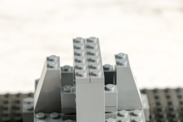 Close-up of LEGO tower top, grey bricks and slopes on black baseplate