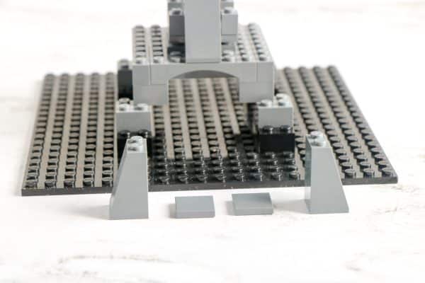 LEGO tower from front view, showing arch and slopes on a black baseplate
