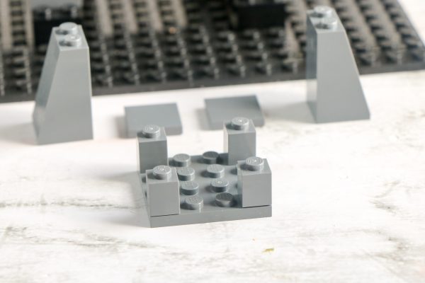 Grey LEGO bricks with two sloped pieces in the background