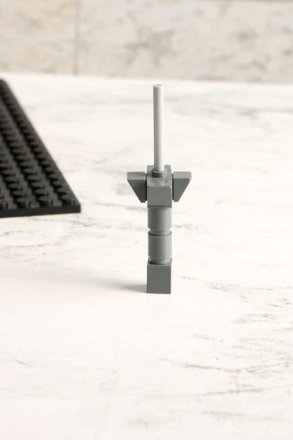 A LEGO structure standing upright on a white marbled surface