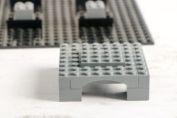 grey LEGO arch structure placed on a flat surface