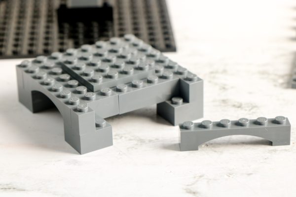 A grey LEGO arch structure alongside a 6x8 plate