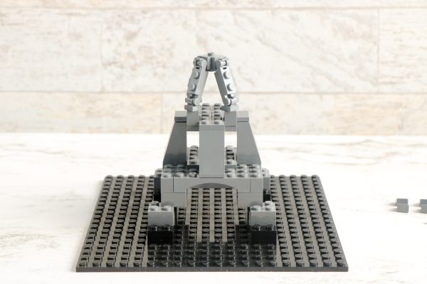 LEGO tower structure with a chain element on top displayed on black baseplate