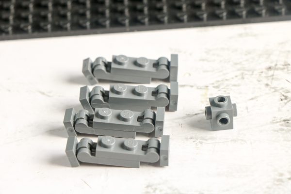Grey LEGO pieces with a black baseplate in the background