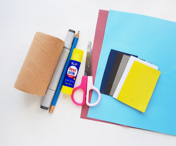 Craft supplies including scissors, glue, pen, and colored papers