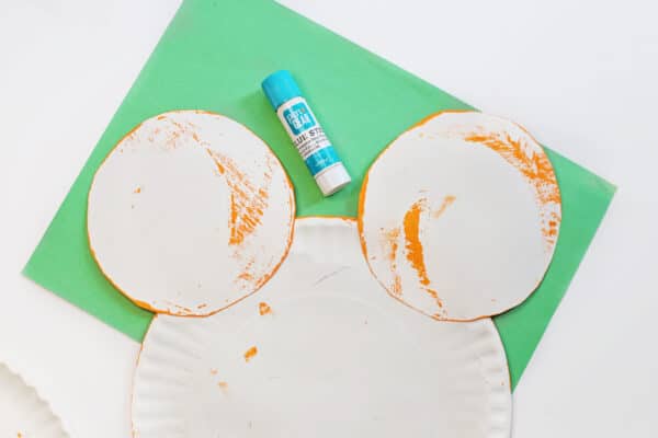 glue the cut out ears to the mickey mouse paper plate