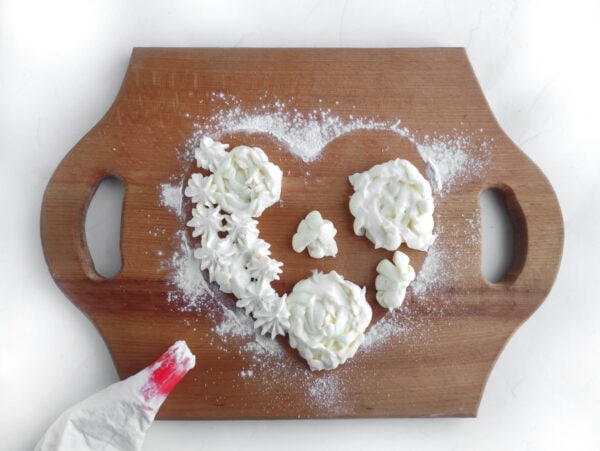 extra melted white chocolate in a piping bag and design the cupid shape outline in the center