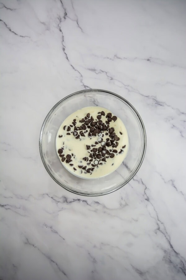 Heat the heavy cream in a small saucepan over medium heat until it just begins to simmer. Pour the hot cream over the chocolate chipped in a heatproof bowl.