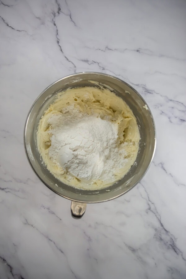 Add powdered sugar: Gradually add the powdered sugar, 1 cup at a time, beating until smooth.