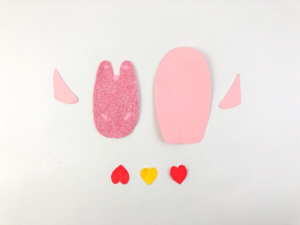 Using your scissors, carefully cut out the penguin's body, wings, beak, feet, and any additional heart shapes from your colored construction paper