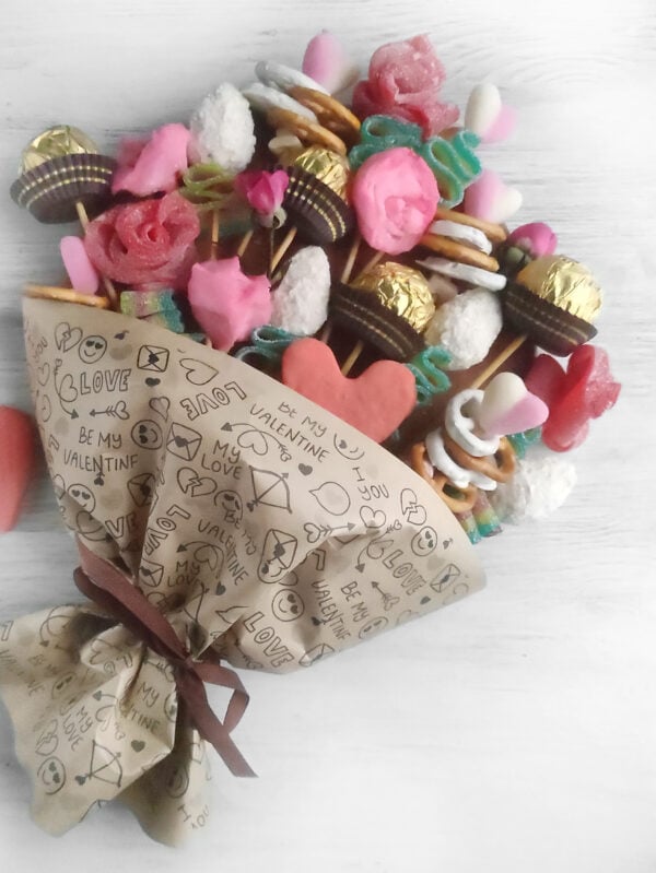 A vibrant and colorful Valentine’s Day candy bouquet charcuterie board, featuring an assortment of chocolates, gummies, and heart-shaped treats arranged in a festive display