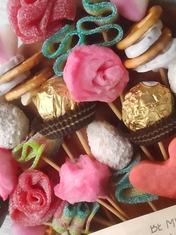A beautifully arranged Valentine’s Day candy charcuterie board featuring an array of chocolates, colorful gummies, and heart-shaped confections, perfect for sharing with loved ones.
