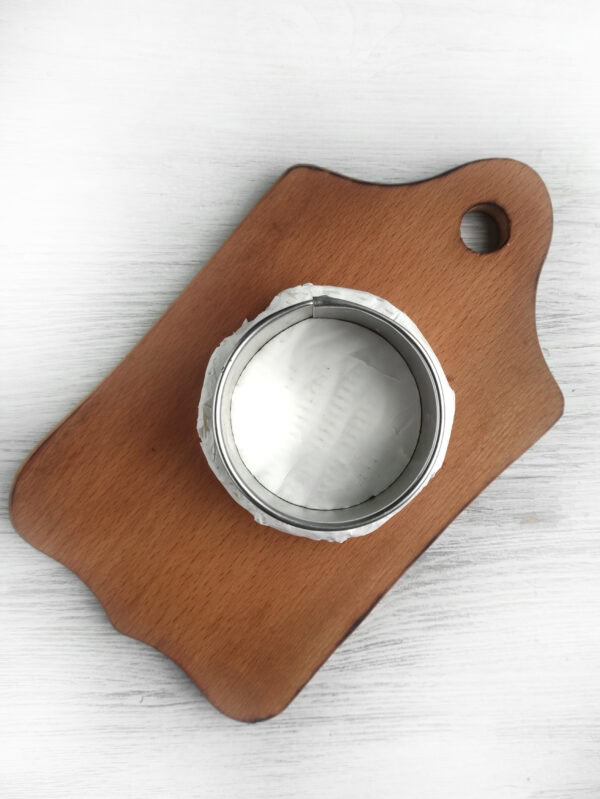 A wooden board with an open tin can placed on top