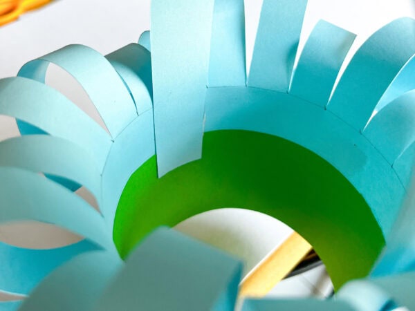 Interior view of the paper basket showing the green base and blue curled strips forming a circular pattern