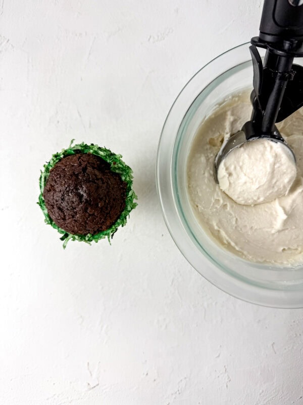 Frosting scooped from a bowl to form the top of the cupcake cone