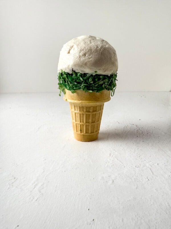 Ice cream cone topped with a large scoop of frosting