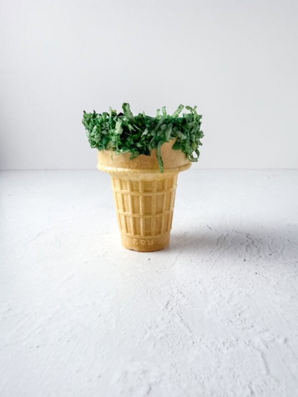 Ice cream cone standing upright with shredded coconut