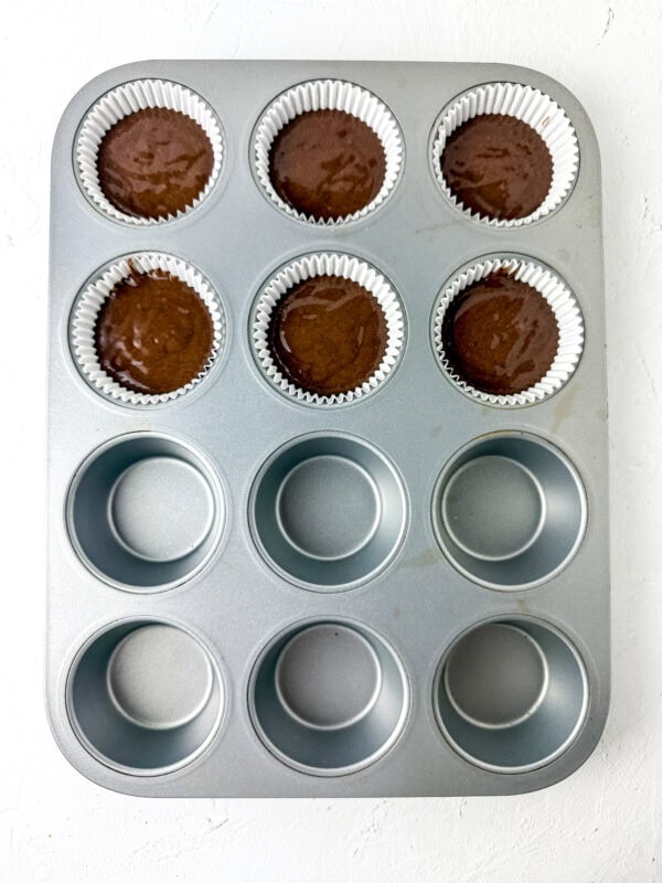 add the chocolate cupcake batter to the muffin liners in the muffin pan