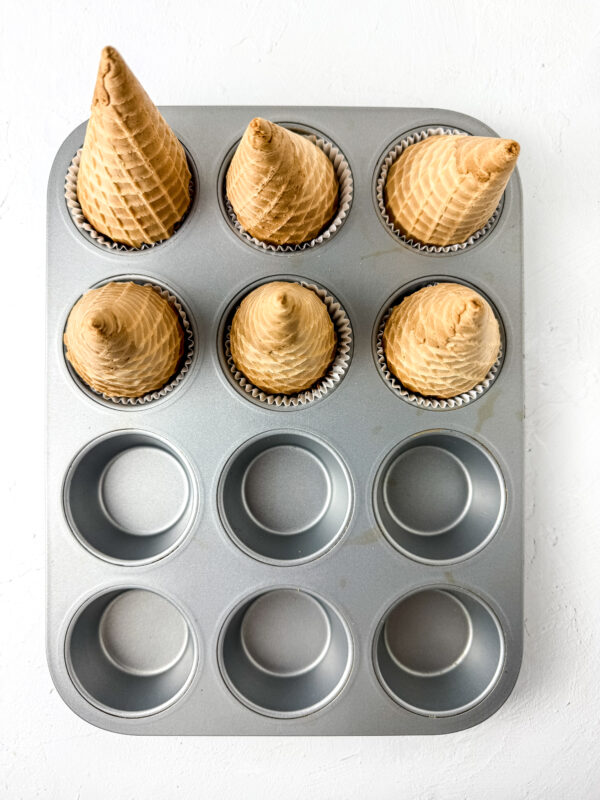 place the sugar cones upside down on the baking tray and in the cupcake mix