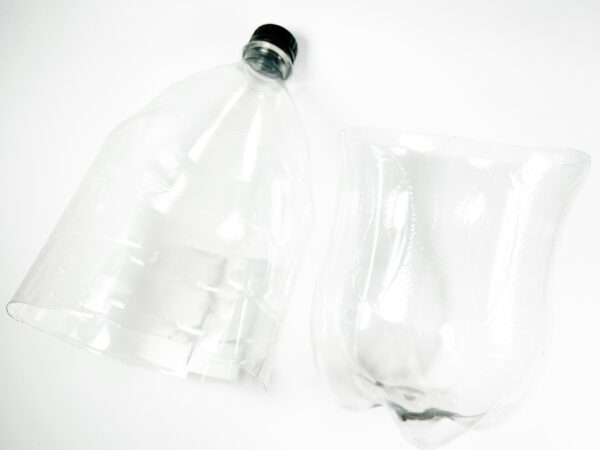 Plastic bottle cut in half, showing separated top and bottom sections.
