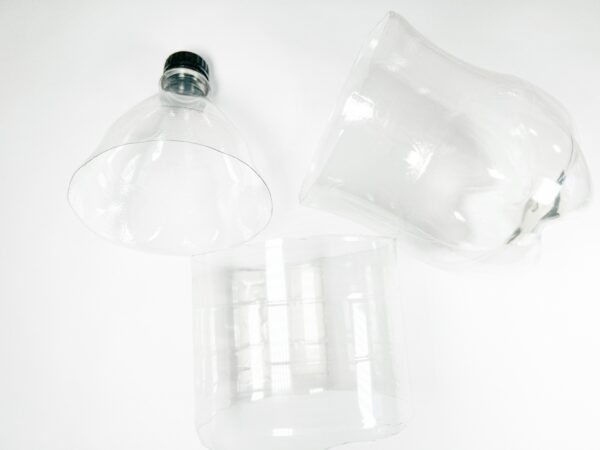 Three parts of the plastic bottle: top, middle, and bottom, fully detached and ready for use.
