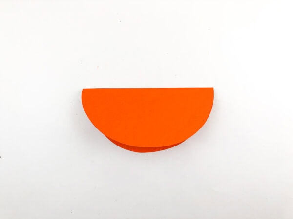An orange paper semicircle folded in half.