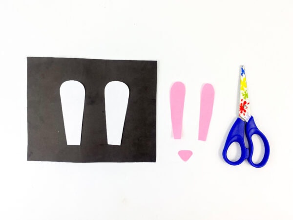 Cut-out bunny ears in white and pink, along with a small pink nose shape.
