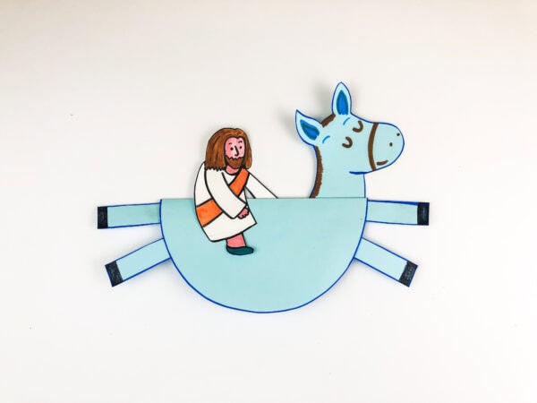 A paper donkey craft with a cutout figure of Jesus sitting on its back.