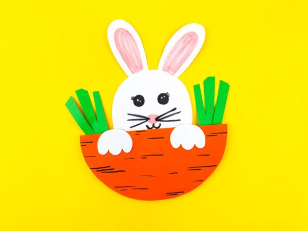 A close-up of the paper bunny inside the carrot pocket with green paper tops.