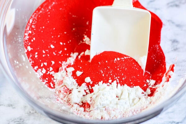 A bowl of red colored sand with cornstarch sprinkled on top
