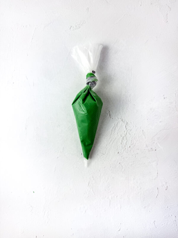 Green candy melt in a piping bag tied at the top.