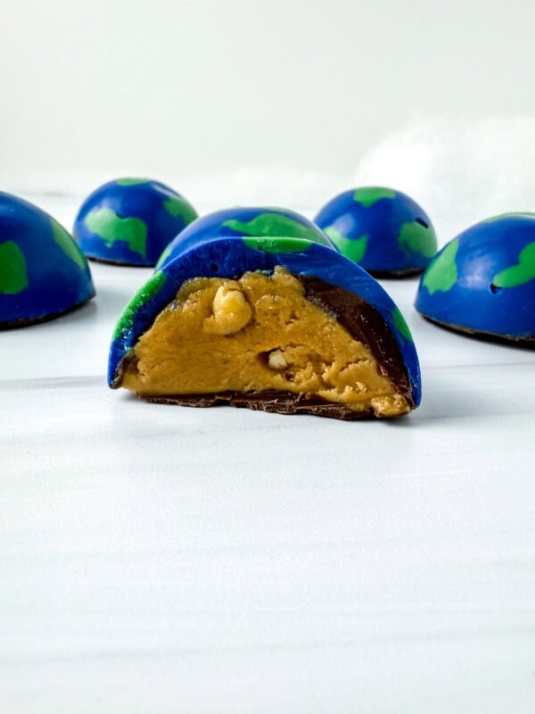 Earth-shaped chocolate ball cut in half, revealing a peanut butter filling.