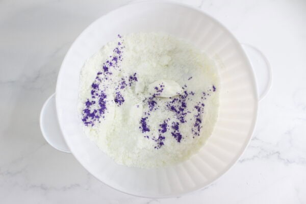 Dry mixture with purple coloring in a white bowl.