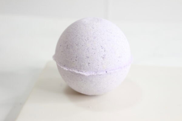 Finished lavender bath bomb on white tile.