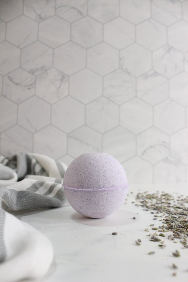 Lavender bath bomb next to dried lavender.