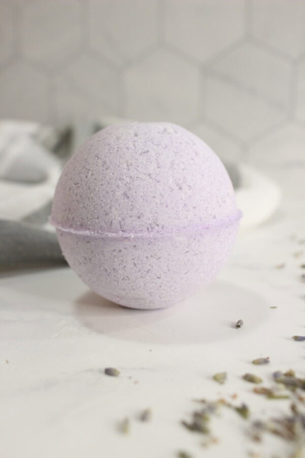 Purple lavender bath bomb on a white surface.