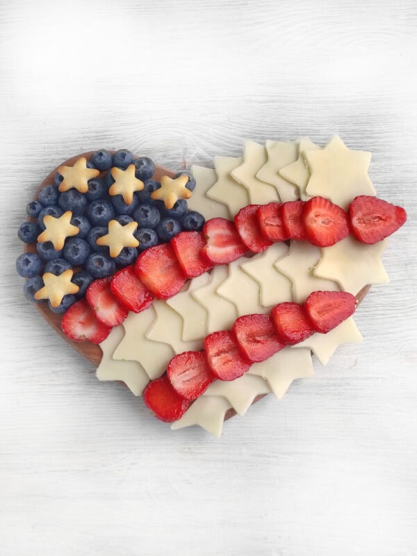 Nearly completed patriotic board with blueberries and star crackers added to the top left corner to resemble the flag’s stars.