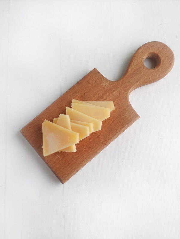 Slices of triangle cheese on a wooden mini board